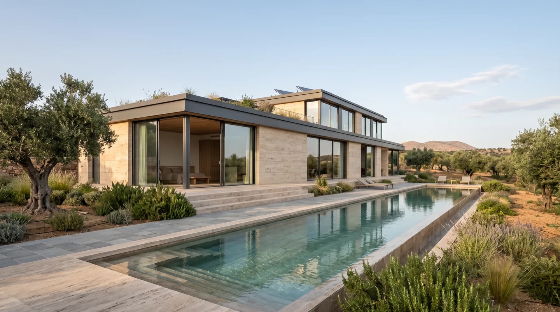 Villa contemporánea con fachada de piedra travertino y piscina alargada